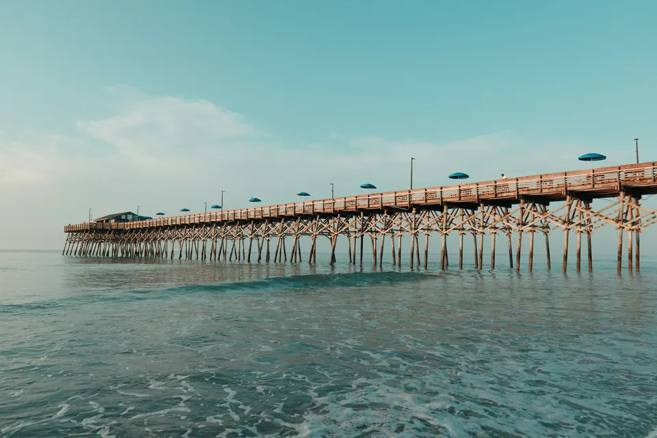 The fishing pier at Garden City Beach stretching over calm water