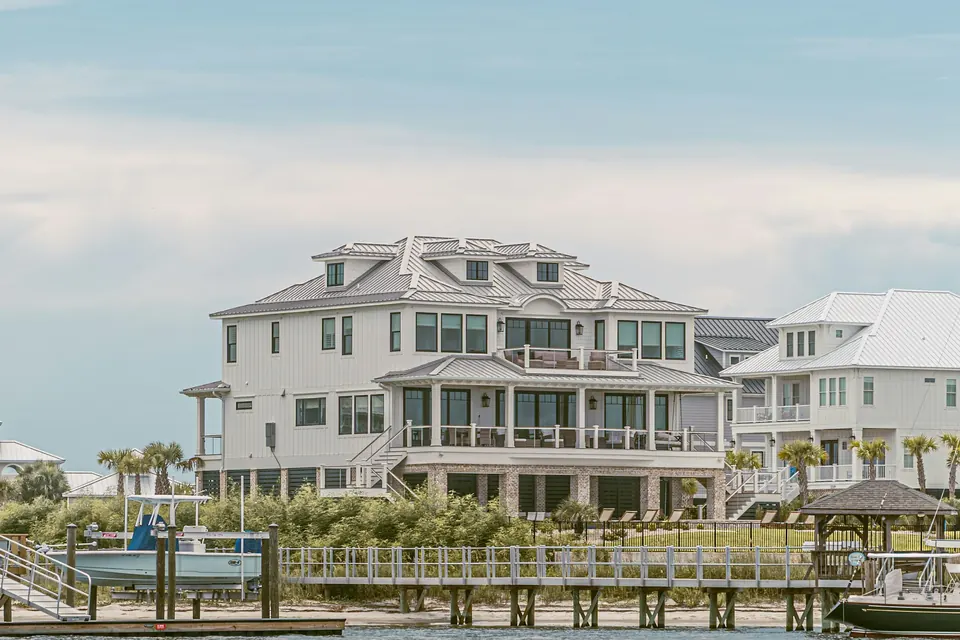 A large white waterfront home with a private dock in Murrells Inlet